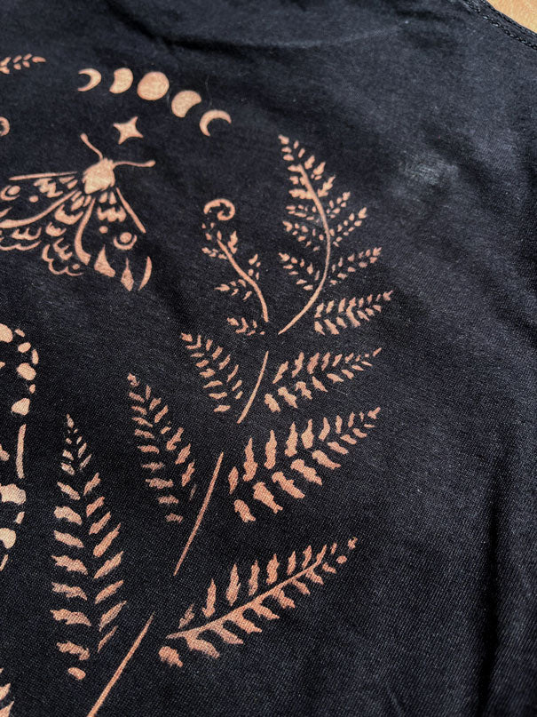 Close-up detail of stencil bleach art fern design on black fabric