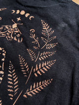 Close-up detail of stencil bleach art fern design on black fabric