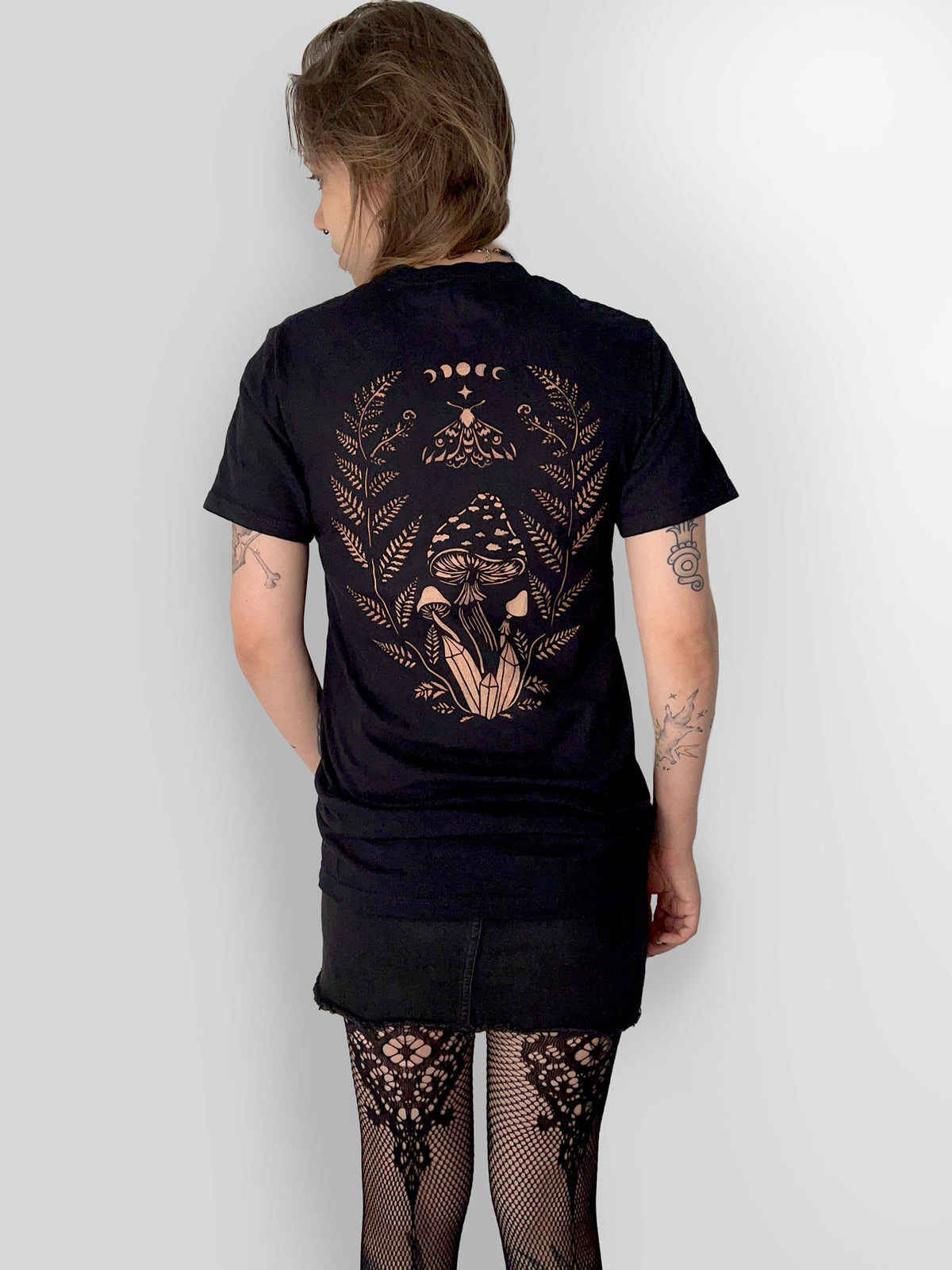 stencil bleach art t-shirt back design featuring mushrooms, ferns, moon phases, a moth and crystals on black fabric